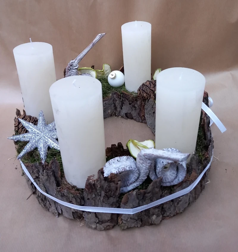 Kranz mit Rinde, weißen rustikal Kerzen und Deko.