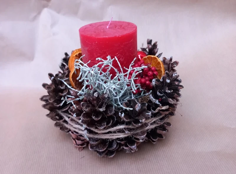 Rundes Gesteck mit Zapfen, rote rustikal Kerze und Deko.