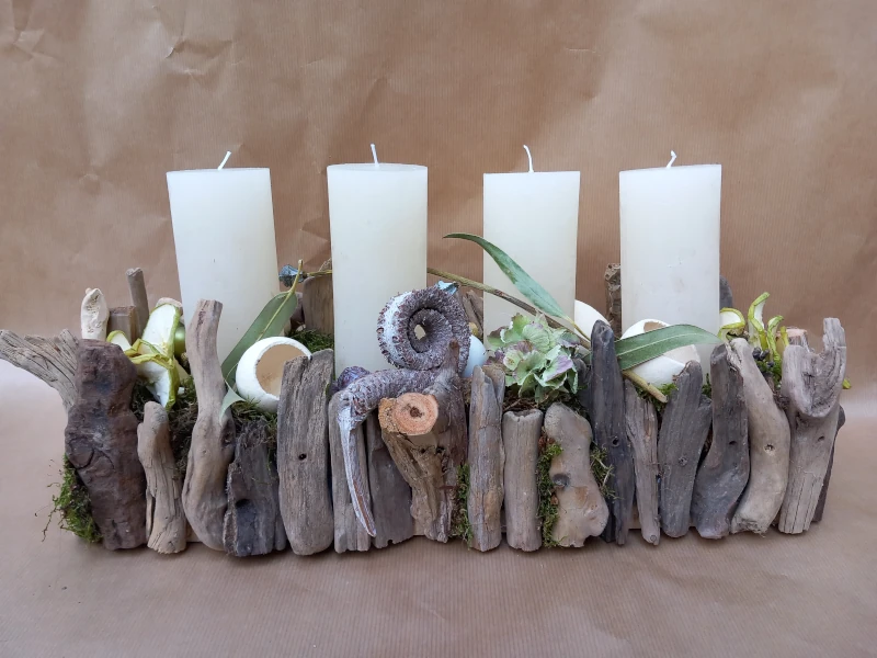 Längliches Gesteck mit Schwemmholz und weißen rustikal Kerzen. Längliches Gesteck mit Schwemmholz und weißen rustikal Kerzen.