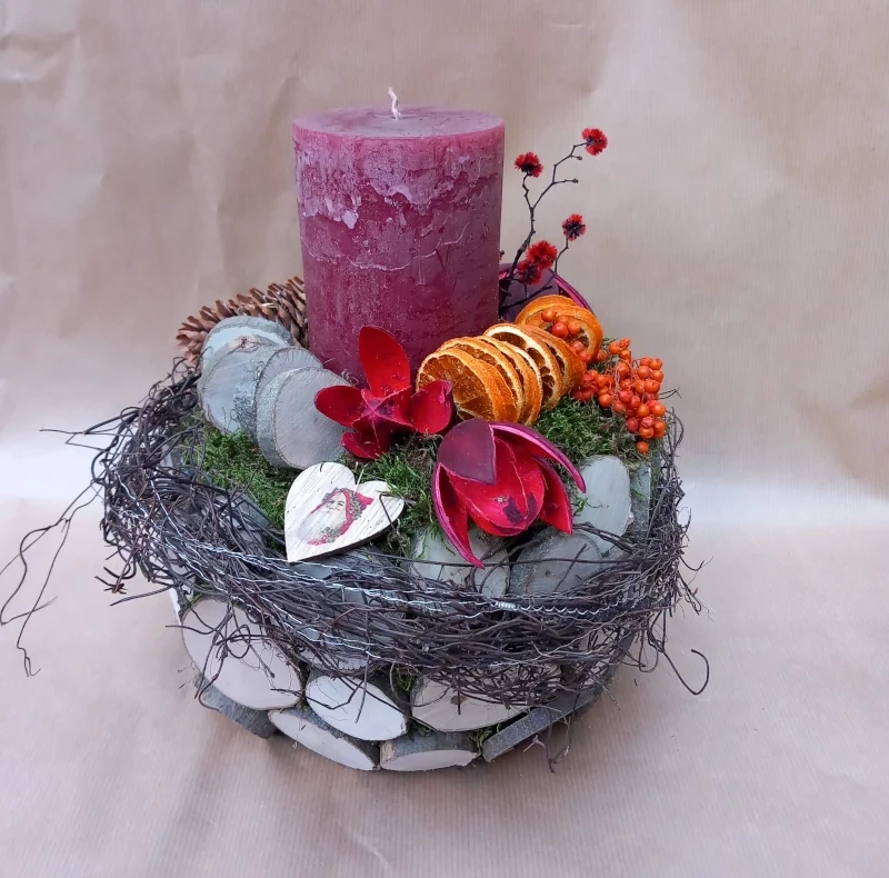 Rundes Gesteck mit einer roten rustikal Kerze und Deko.