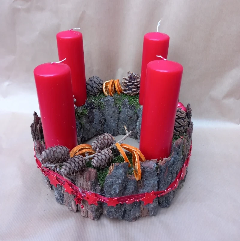 Kranz mit Rinde, klassisch roten Kerzen und Deko.