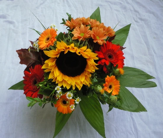 Strauß mit Sonnenblume, Gerbera, Germini, Kamille und rotes Laub.